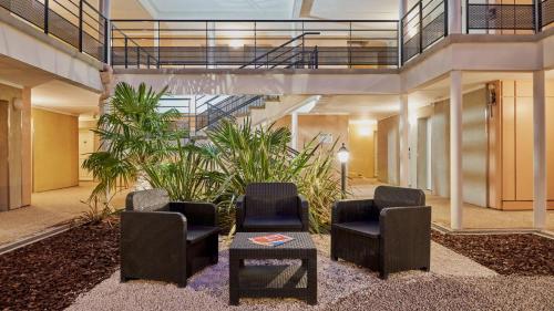 a lobby with two chairs and a table and plants at Résidence Château du Mée in Le Mée-sur-Seine