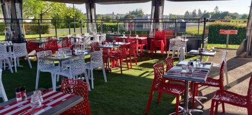 - un ensemble de tables et de chaises sur une terrasse dans l'établissement Contact Hôtel Fontenay le Comte, à Fontenay-le-Comte