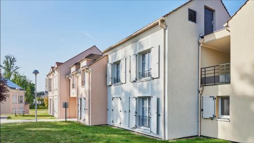 a row of white buildings with windows at Résidence Château du Mée in Le Mée-sur-Seine