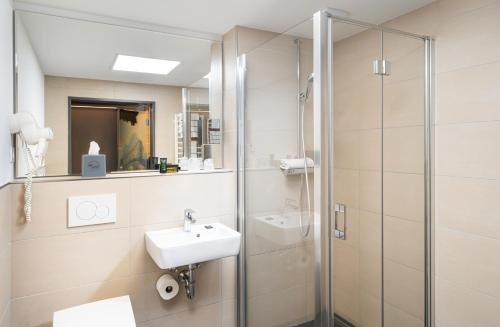 a bathroom with a sink and a shower at Food Hotel in Neuwied