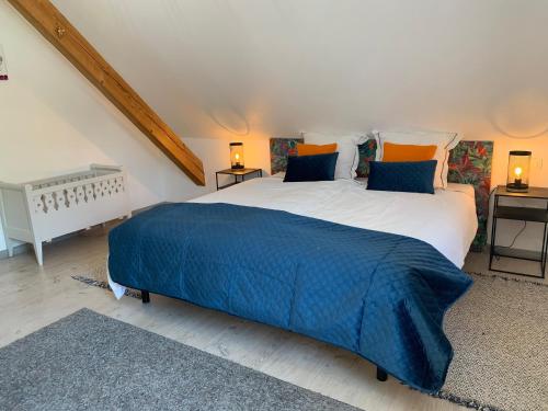 1 dormitorio con 1 cama grande con manta azul en Gîte des biches, en Birkenwald