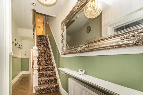 a stairway with a large mirror and a stair case at Cherry Tree House in Blackpool