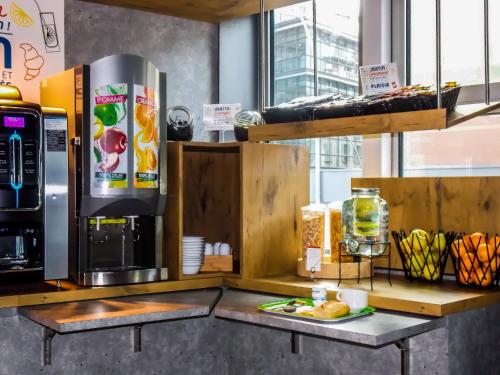 a kitchen with a refrigerator and a coffee maker at ibis budget Porte D'Orleans in Paris