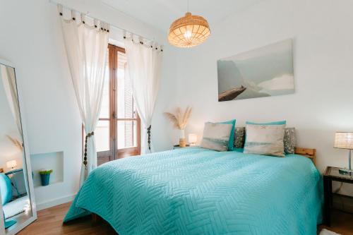 une chambre avec un lit bleu et une fenêtre dans l'établissement One bedroom Nomad Dreams N2, à Cascais