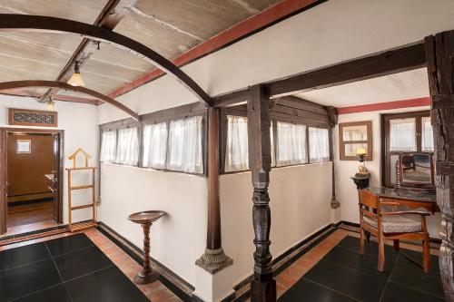 a room with a table and a chair and windows at Neemrana Fort-Palace in Neemrana