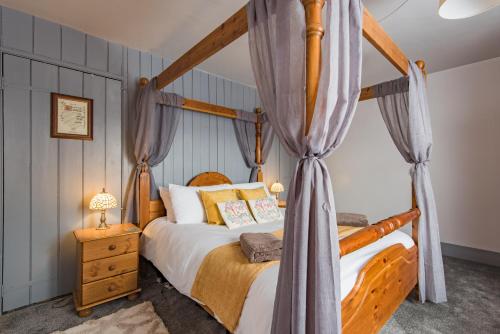 1 dormitorio con cama con dosel y cortinas en Castle View - Charming cottage with views of Dover Castle en Kent
