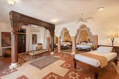 a bedroom with two beds and a ceiling fan at Neemrana Fort-Palace in Neemrana
