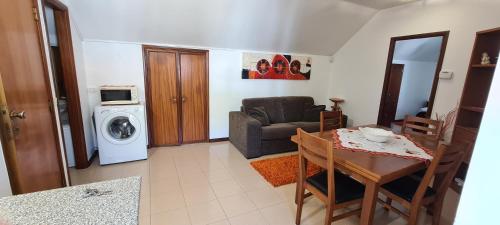 ein Wohnzimmer mit einem Sofa, einem Tisch und einer Waschmaschine in der Unterkunft BBL APARTAMENTOS - B in Nazaré