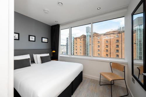 a bedroom with a bed, chair and a window at Staycity Aparthotels Manchester Piccadilly in Manchester