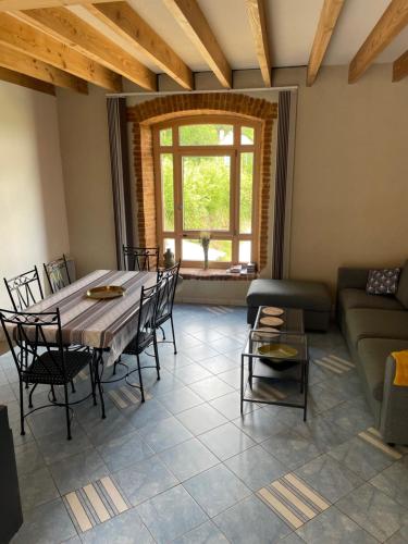 sala de estar con mesa, sillas y sofá en Le Moulin de cherré gîte bleu, en Aubigné-Racan
