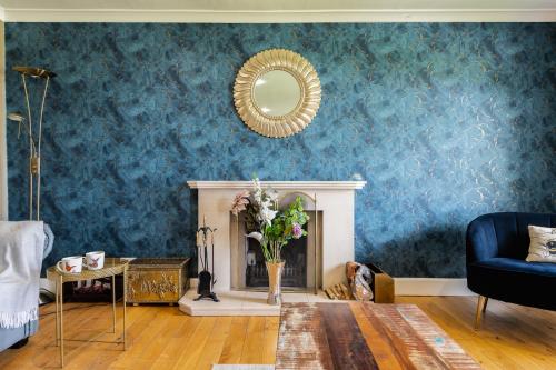 un soggiorno con camino e specchio di Alton Villa, Sleeps 12, Great for Families, Undercover Hotub & Games Room a Newmilns