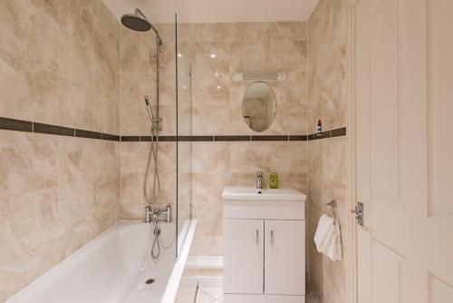 a bathroom with a tub and a sink and a shower at Blackhorse Loft - spacious apartment by the sea in Deal