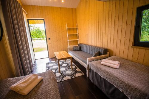 Habitación con 2 camas, sofá y mesa. en Vetsi Talli Holiday Village en Kassari