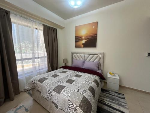 a bedroom with a bed and a large window at 1 Bedroom in Jumeirah Beach Residence Dubai in Dubai