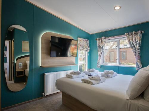 a bedroom with a large bed with a mirror at Golden Sands Holiday Park in Kinmel Bay
