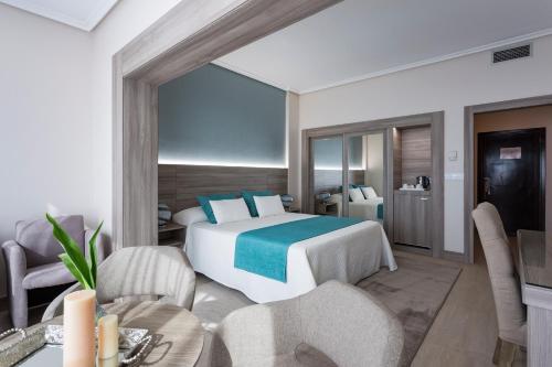 a bedroom with a bed and a table and chairs at Eurostars Louxo Talaso in Isla de la Toja