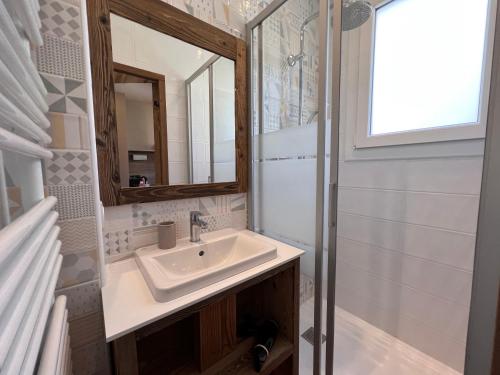 une salle de bain avec un lavabo et un miroir dans l'établissement OURS BLANC 29 duplex avec vue, à La Clusaz