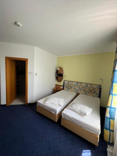 AfumaţiにあるHotel Doi Taurasiのベッド2台と廊下が備わるホテルルームです。