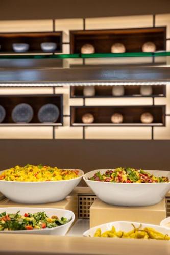 a kitchen with three bowls of food on a counter at Lagas Aegean Village in Kardamaina