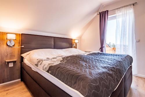 a bedroom with a large bed and a window at Lipno - Lakeside Village - Větrník in Frymburk