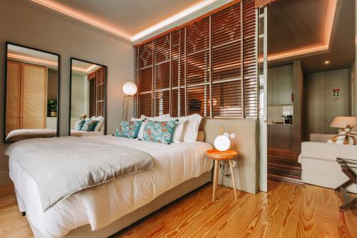 a bedroom with a large bed and a living room at Torel 1884 Suites & Apartments in Porto
