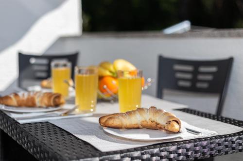 uma mesa com dois pratos de pão e copos de sumo de laranja em Apartment Happiness Biograd na moru em Biograd na Moru