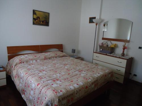 een slaapkamer met een bed, een lamp en een dressoir bij La casa di Anna in Scorzè