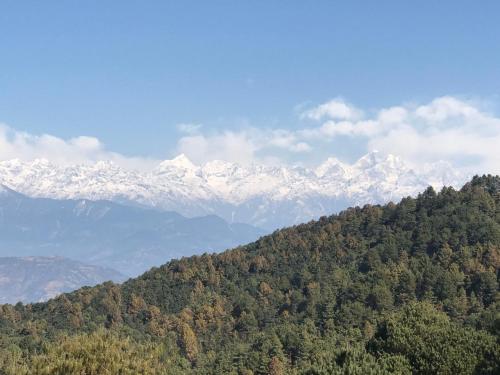 una montaña con montañas nevadas en la distancia en Millennium Blue, en Nagarkot