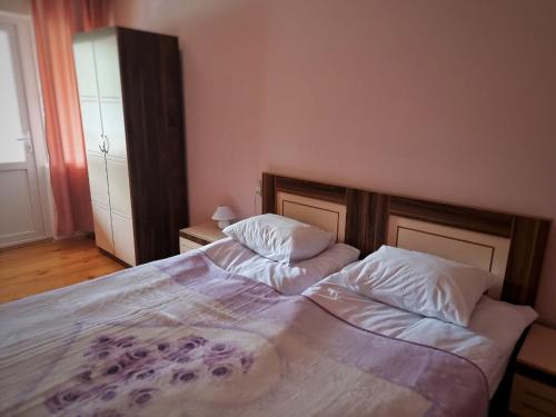 a bedroom with a large bed with two pillows at Girgola in Mestia