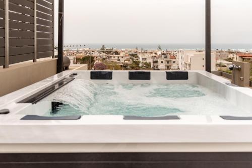 a jacuzzi tub with a view of a city at Sapphire Horizon Suites in Kissamos