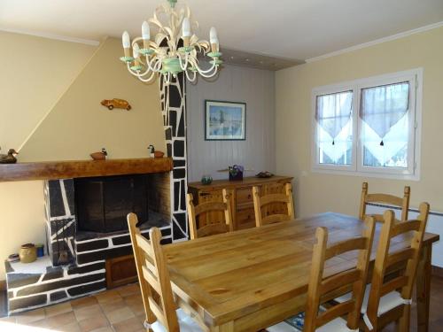 une salle à manger avec une table et une cheminée dans l'établissement Holiday Home in Penestin near Mine d'Or Beach, à Pénestin