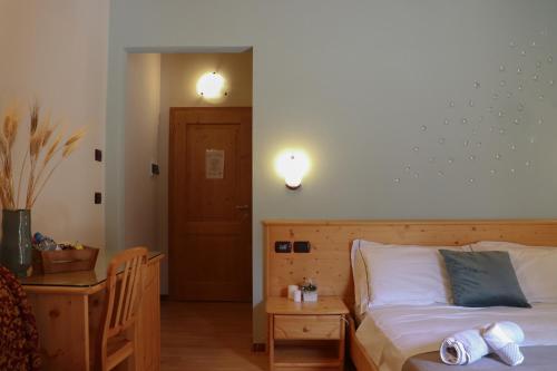 a bedroom with a bed and a table and lights at hotel Parco Pineta in Cavareno