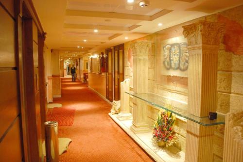 a hallway of a building with columns and flowers at Hor Moheb Hotel in Cairo