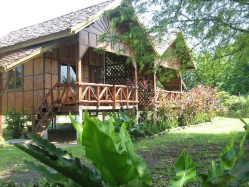 a wooden house with a wooden bridge in front of it at Sainamhai Resort in Ban Namsanam