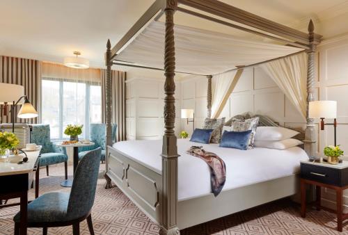 a bedroom with a four poster bed and a desk at Castlecourt Hotel, Spa & Leisure in Westport