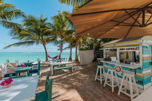 a bar on the beach with palm trees and the ocean at Green Coast Beach Hotel in Punta Cana