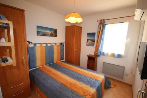une chambre avec un lit et une fenêtre dans l'établissement Jolie maison de vacances climatisée, WIFI, 2 chambres terrasse parking privatif plein sud dans résidence sécurisée avec piscine commune 800 m de la mer LRCS138, à Portiragnes