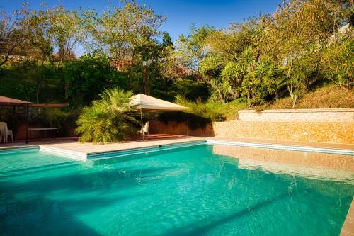 a swimming pool with blue water in a yard at Casa Santa Teresita - Cabaña tipo glampling in Sanarate