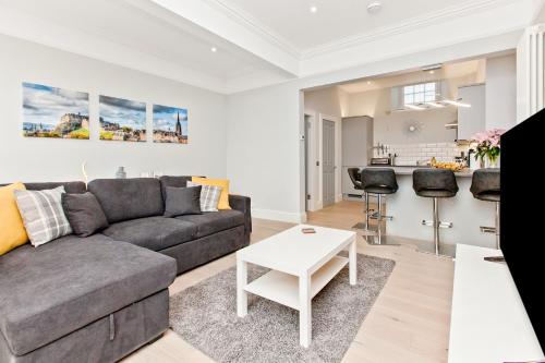 a living room with a couch and a table at Modern & Spacious 1 Bed Apt, West End in Edinburgh