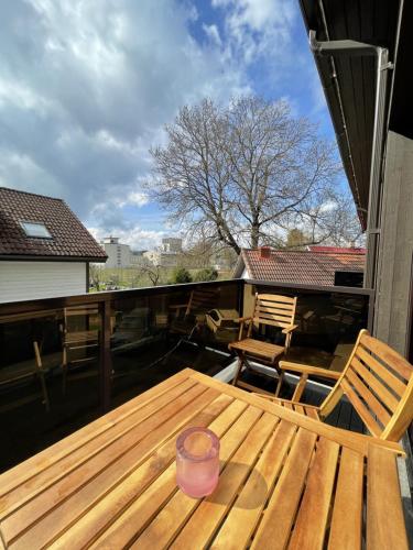 a wooden table and chairs on a balcony at Guest House Bermuuda Family Apartment in Paide