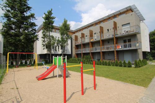 einen Spielplatz vor einem großen Gebäude mit einem Gebäude in der Unterkunft Apartamenty Świnoujście - Bałtycka in Świnoujście
