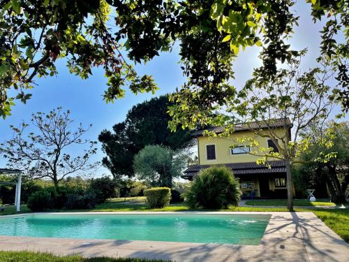 a swimming pool in front of a house at SU PASSU Country House in Fertilia