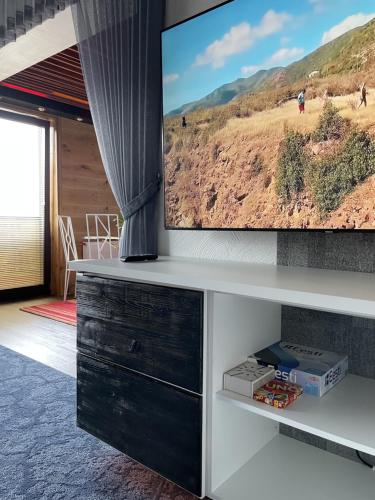 a living room with a flat screen tv on a wall at Guest House Bermuuda Family Apartment in Paide