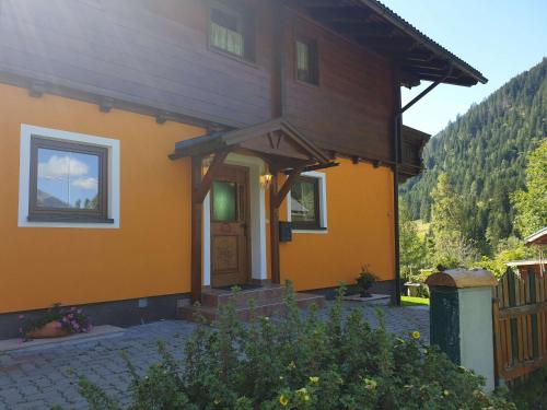a small yellow house with a front door at Almliesl SOEK-660 in Sankt Nikolai im Sölktal
