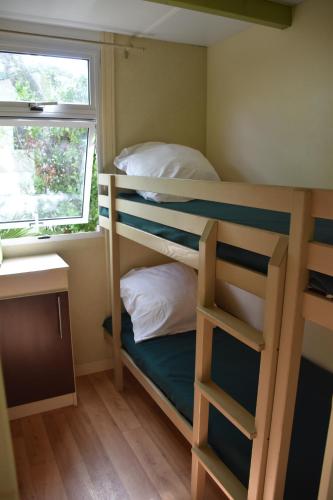 a small room with two bunk beds and a desk at ULVF U Libecciù ** in Calvi