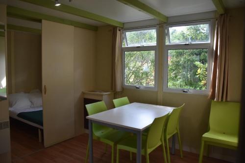 a small room with a table and green chairs at ULVF U Libecciù ** in Calvi