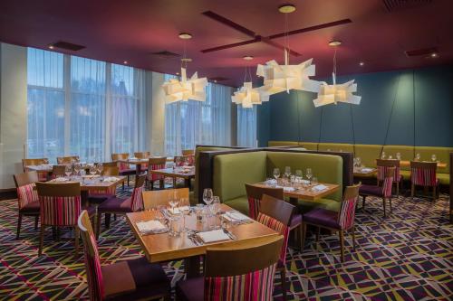 une salle à manger avec des tables, des chaises et des lustres dans l'établissement Ashford International Hotel & Spa, à Ashford
