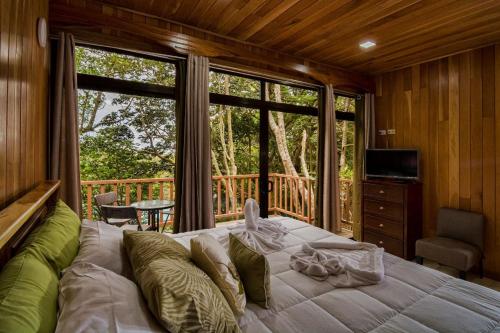 - une chambre avec un grand lit et un balcon dans l'établissement Casa Clusia, à Monteverde Costa Rica