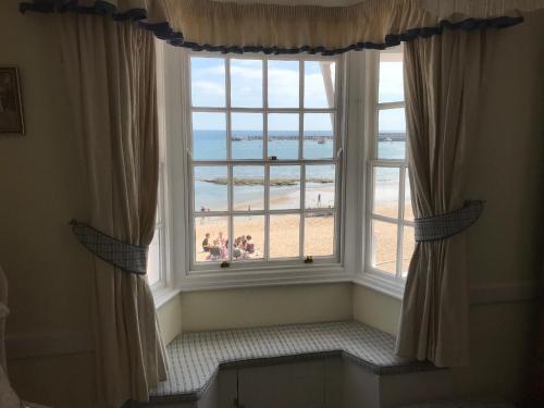 a large window with a view of the beach at Dolphin Cottage Lyme Regis in Lyme Regis