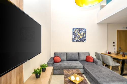 a living room with a couch and a flat screen tv at Sapphire Horizon Suites in Kissamos